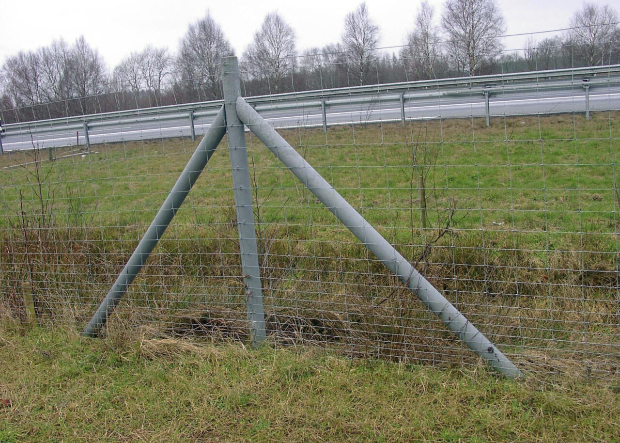 Grey recycled plastic strainer post and strut supporting a wire mesh fence